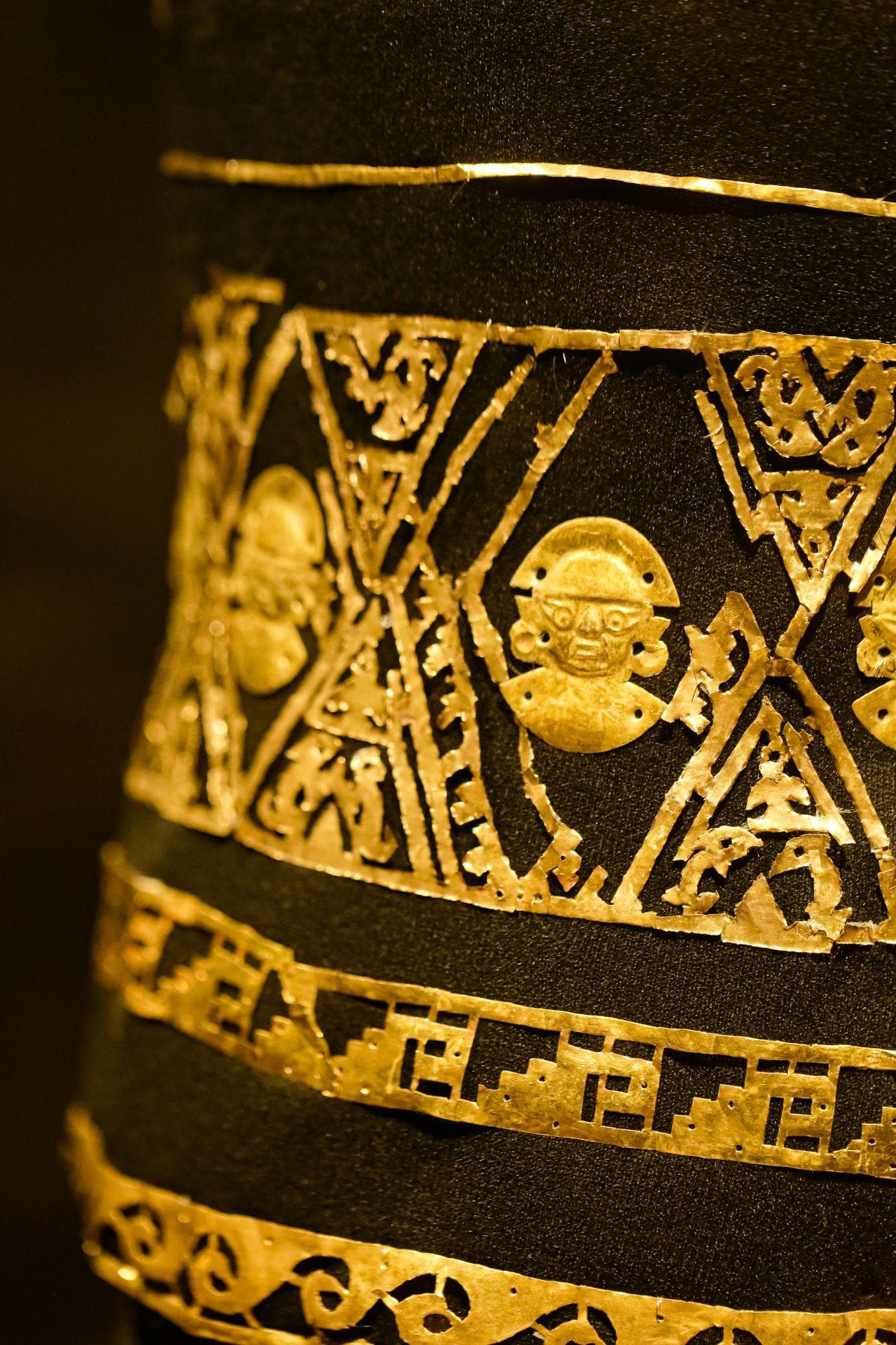 Detalle de una pieza de orfebrería precolombina sobre fondo oscuro