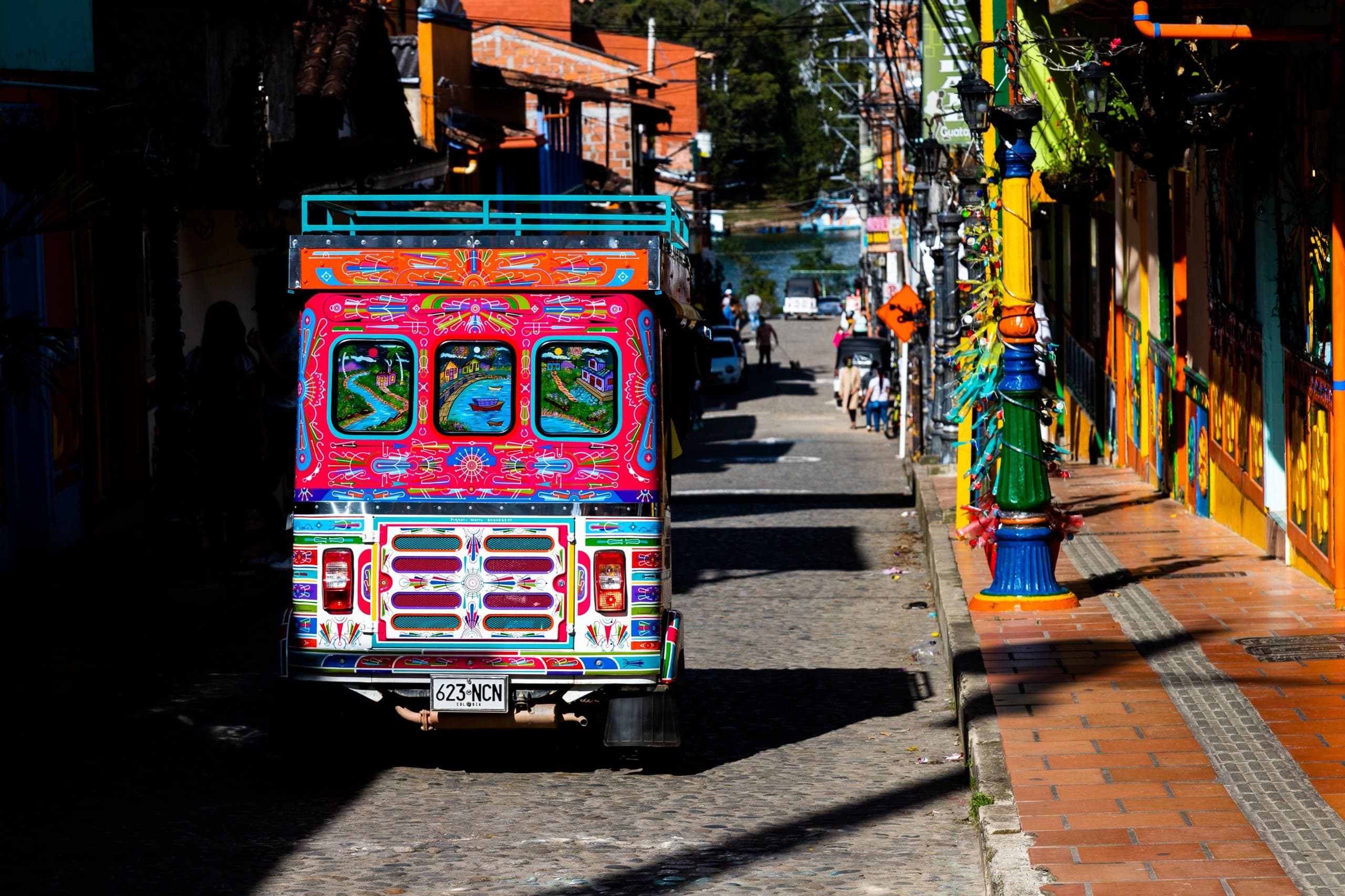 Calle de una ciudad colombiana con un autobús de colores